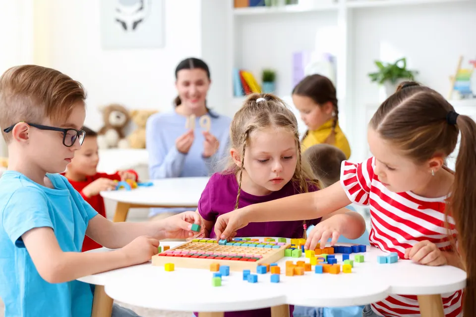 Niños comparten un juego con piezas de construcción